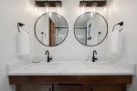 Full bathroom with gorgeous white tile throughout and double vanities